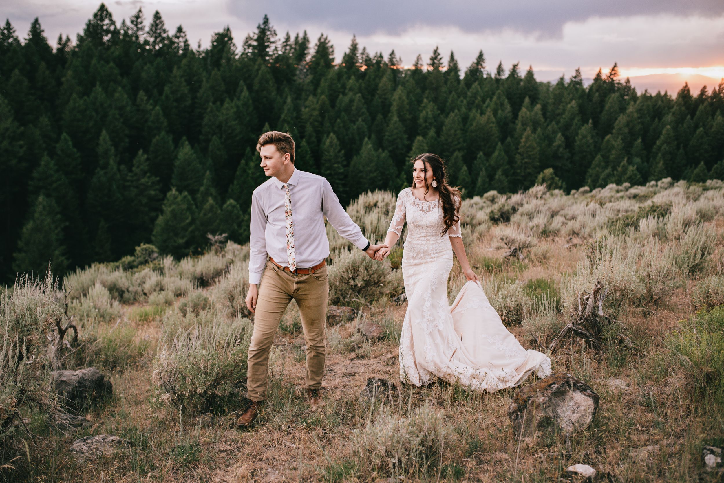 bridal couple walking on the edge of a cliff forest in east idaho